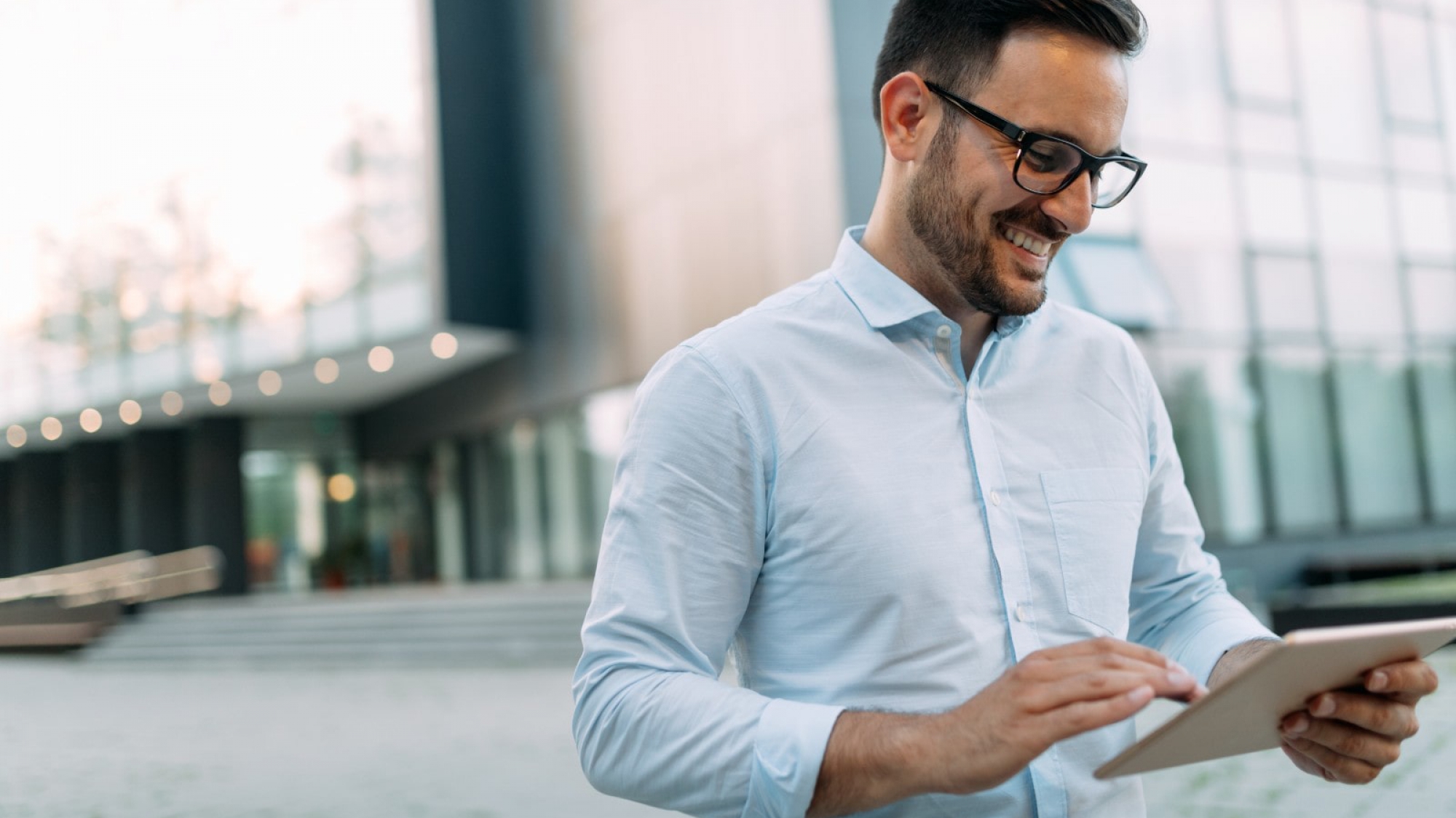 portrait-of-businessman-in-glasses-holding-tablet-AWVHCJ67U-min